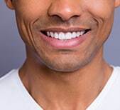 Man smiling with healthy white teeth in dental practice portrait.