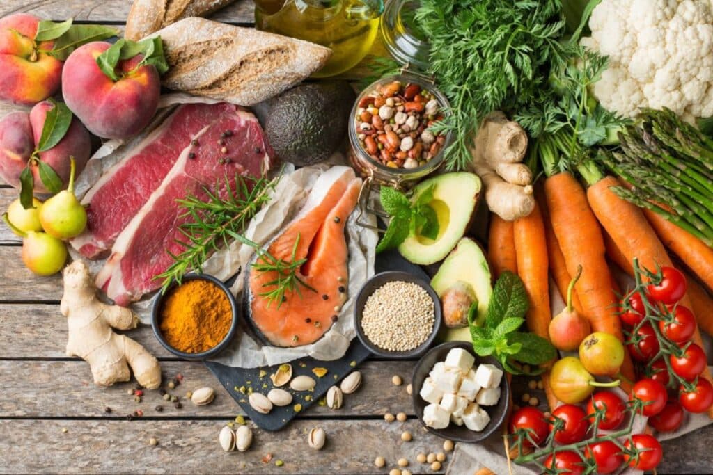 Healthy foods including lean meat, fresh vegetables, fruits, nuts, and whole grains support dental wellness.