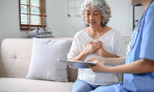 Healthcare provider in blue scrubs consulting with senior patient about nursing care treatment in Niceville.