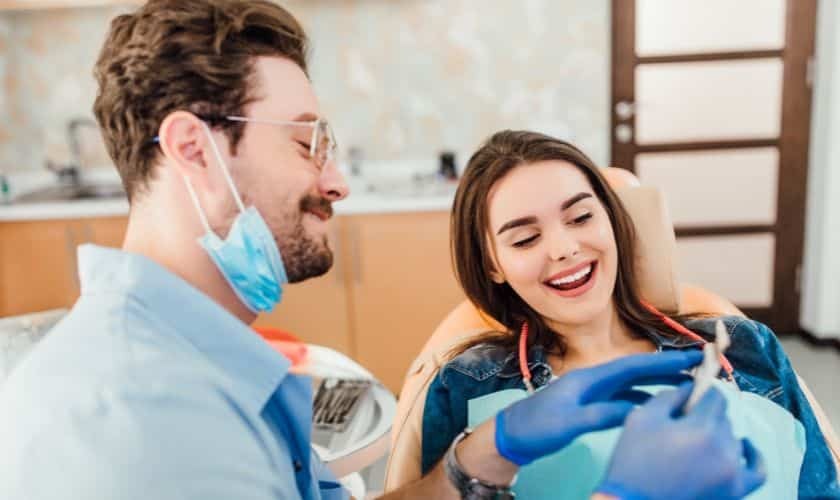 Dentist showing treatment plan to smiling female patient at Niceville dental office.