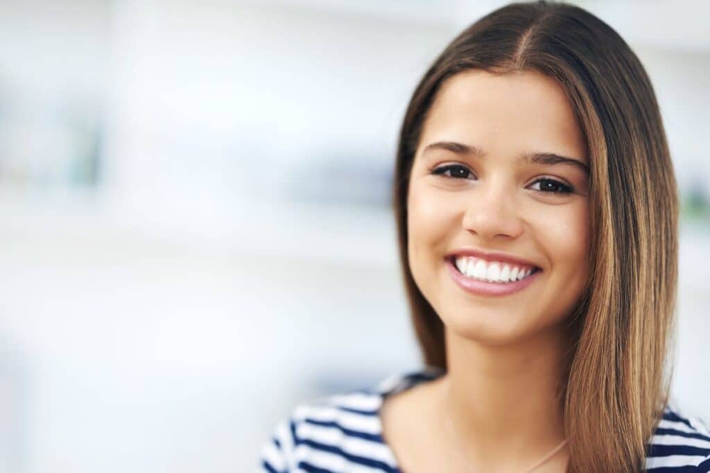 Smiling woman with straight teeth after Invisalign treatment in Niceville, FL.