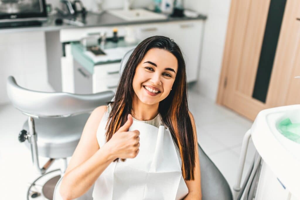 Happy patient giving thumbs up in modern dental office in Niceville, FL.