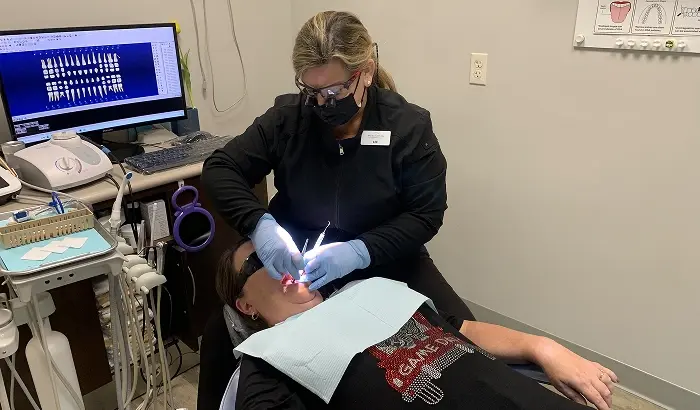 Dentist performing intraoral examination on patient in Niceville dental office.