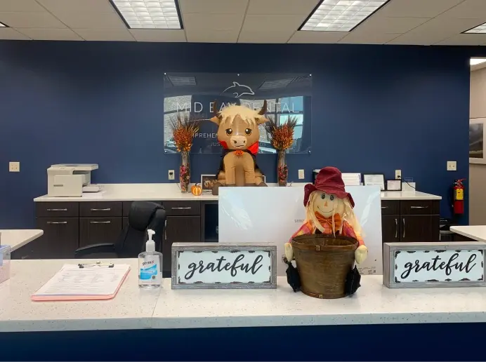 Dental office reception desk decorated with fall decorations and grateful signs.