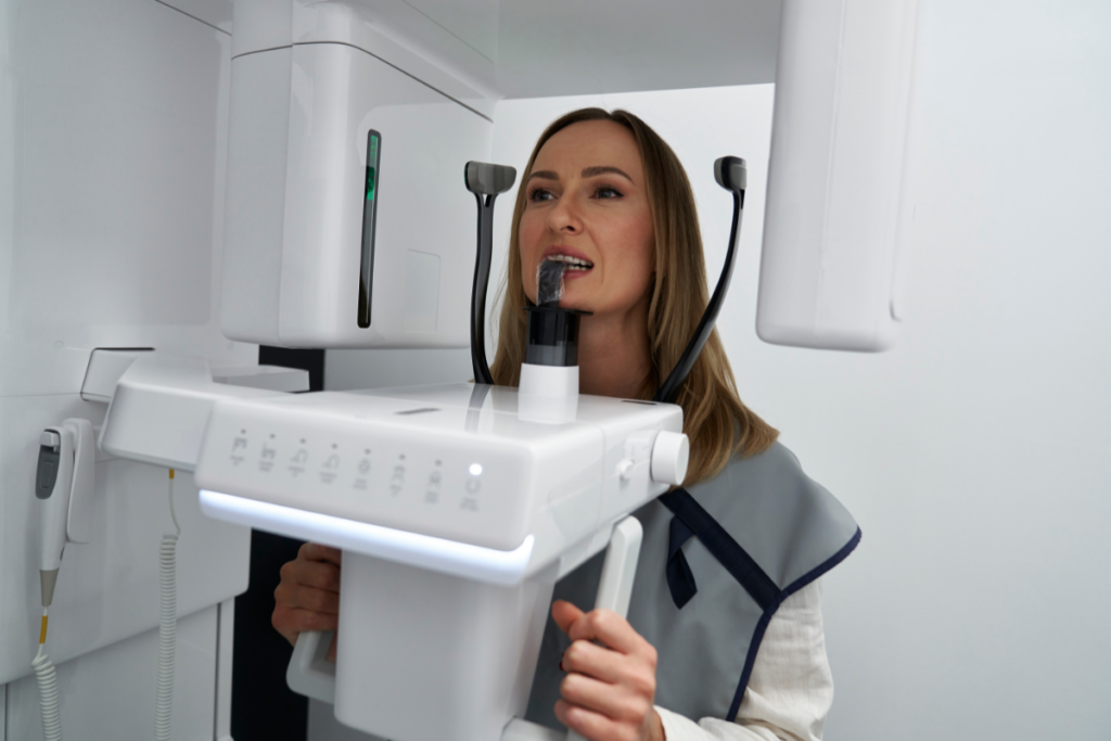 Woman demonstrating advanced dental imaging equipment used in modern digital dentistry treatments.
