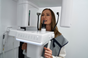 Woman demonstrating advanced dental imaging equipment used in modern digital dentistry treatments.