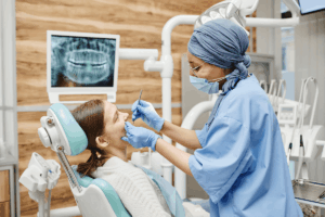 Dentist examining patient's teeth in modern Niceville dental office with X-ray display.