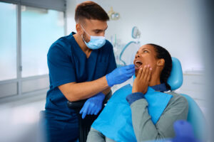 Dentist examining patient's teeth during oral checkup in modern dental office.